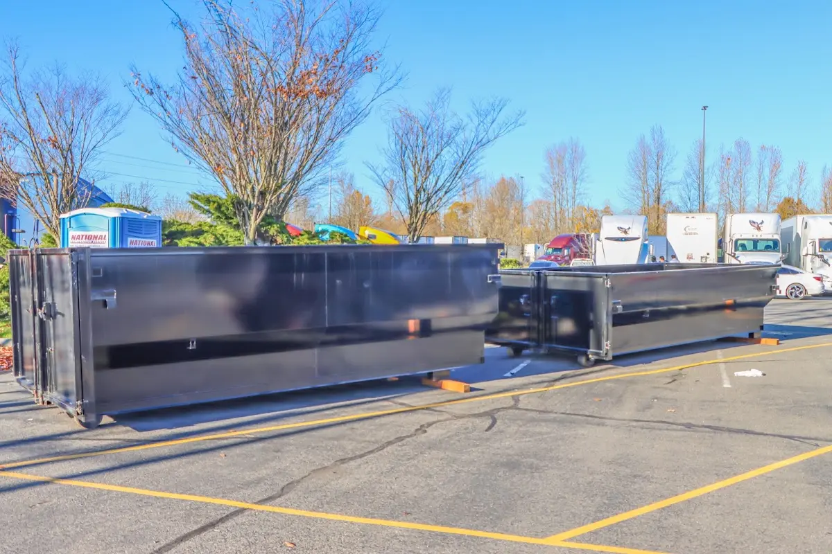 Professional dumpster rental service with roll-off container on residential driveway in Three Lakes